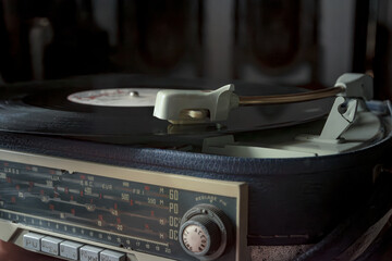 Vintage turntable with vinyl and radio tuner.