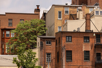 Naklejka premium Morning sun shines on beautiful historic building architecture in the heart of the Mount Vernon neighborhood of Baltimore, Maryland, USA.