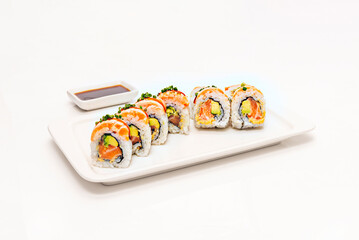 Avocado and asparagus uramaki with reduced soy sauce, on a square porcelain plate