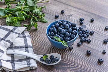 Composition with blueberries on a black velvet background and a blown-glass spoon with trapped bubbles