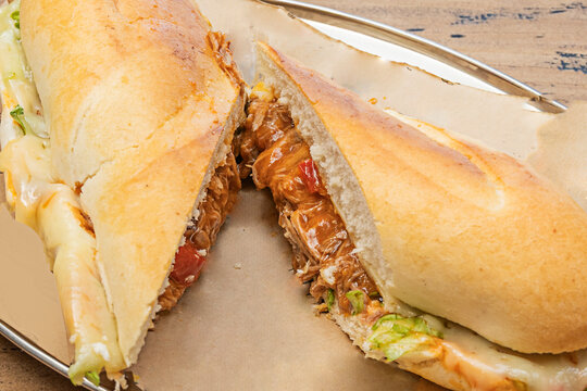 Pulled roast chicken sandwich with black garlic mayonnaise and fresh iceberg lettuce on a crispy baguette