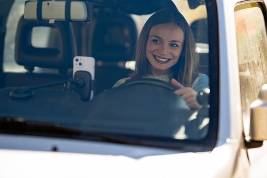 Woman driving car using smartphone navigation - Powered by Adobe