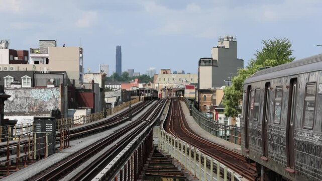 new york subway train elevated track with trains moving and nyc skyline in the background (outdoor subway d line in sunset park 62nd street brooklyn) scenic view skyscrapers downtown manhattan signal