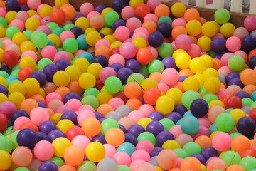 colorful plastic balls in a ball pit the balls are of various colors including red blue green yellow and purple	
