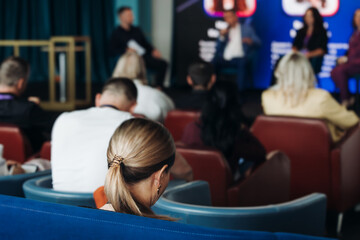 Audience at the modern conference hall listens to panel discussion, people on a congress together listen to speaker on stage at convention, plenary session at business seminar, venue for presentation