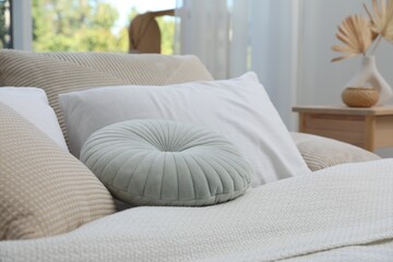 Bed with beautiful pillows in bedroom, closeup
