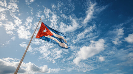 Cuban flag waving majestically against bright blue sky with white cloud. national symbol representing patriotism, pride and freedom