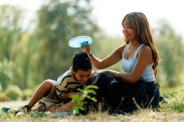 Mother and son enjoying a sunny day outdoors, sharing fun moments and bonding together in a relaxed atmosphere