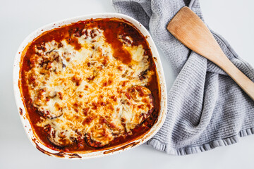 rustic homemade vegetarian eggplant parmigiana in oven tray on kitchen counter