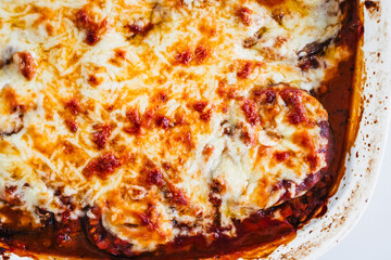 rustic homemade vegetarian eggplant parmigiana in oven tray on kitchen counter