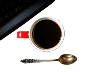 Overhead shot of coffee, spoon, and keyboard on a white surface.
