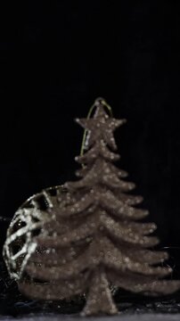 Una toma de cerca de un &aacute;rbol dorado desenfocado  rodeado de luces blancas con un fondo desenfocado. Decoraci&oacute;n de navidad y fin de a&ntilde;o. Video Vertical