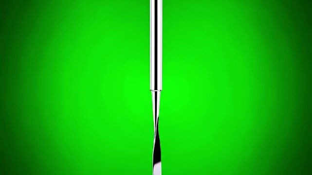 A shiny, metallic, rectangular butter knife angled diagonally against a vibrant green backdrop