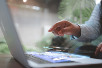 Hand interacting with laptop holographic dashboards for real-time analytics and IoT control