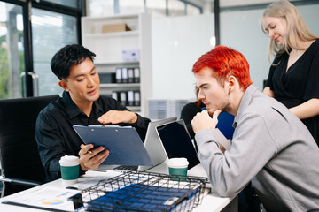 Office colleagues have a casual discussion. During a meeting in a conference room, a group of business teem sit in the conference room new startup project.