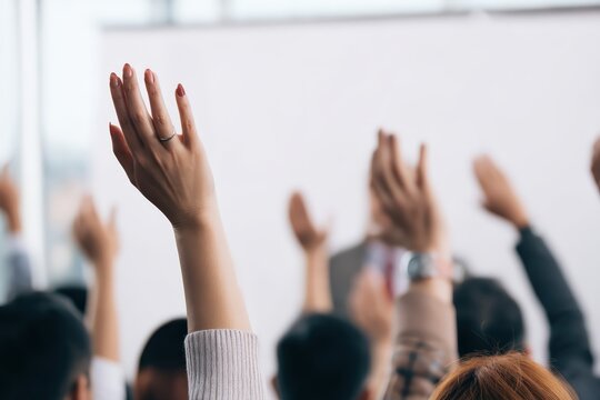 People in an audience raising hands, asking a question, expressing opinion, or showing participation during a business conference - Powered by Adobe