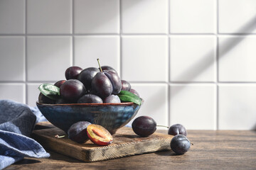 Ripe plums in blue bowl