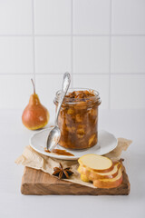 Pear jam in a glass jar with ripe pears