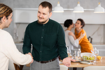 Men shaking hands while greeting each other before a festive dinner