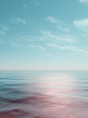 Obraz premium a blurry image of a body of water with a pinkish hue the water appears to be calm and peaceful with no visible movement the sky above the water is a light blue color
