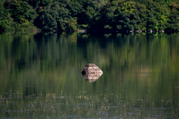 Reflections of rocks and forests on the quiet surface of Lake Onuma