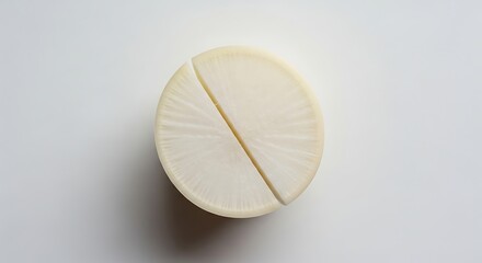 Fototapeta premium Minimalist Overhead Shot of a Sliced Daikon Radish with Subtle Radial Texture and Soft Shadow.