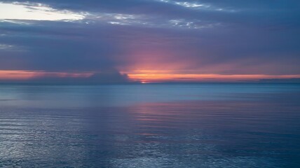 Obraz premium Stunning ocean sunset paints the sky with vibrant pinks and oranges as gentle waves reflect the breathtaking twilight beauty