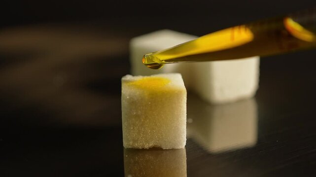 LSD in liquid dropped from pipette to sugar. Lysergic acid diethylamide known as LSD. Also named Acid, lucy, or Ellis D. Semisynthetic hallucinogenic drug made of ergot fungi.