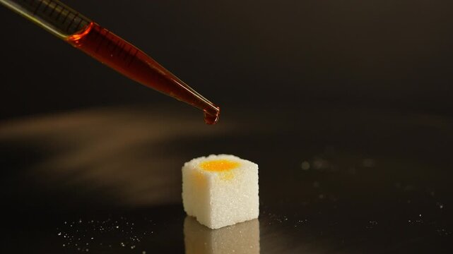 LSD in liquid dropped from pipette to sugar. Lysergic acid diethylamide known as LSD. Also named Acid, lucy, or Ellis D. Semisynthetic hallucinogenic drug made of ergot fungi.