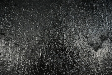 Black background, created by water flowing from the top, black wall as a waterfall.