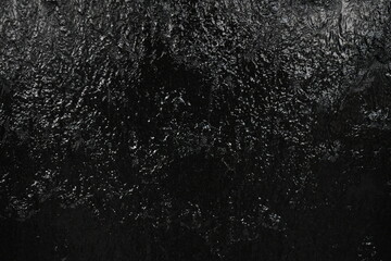 Black background, created by water flowing from the top, black wall as a waterfall.