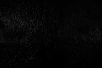 Black background, created by water flowing from the top, black wall as a waterfall.
