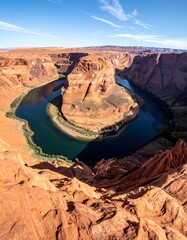 Aerial view of a horseshoe bend carved into sandstone, turquoise water
