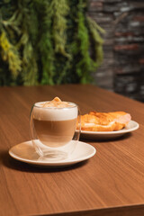 Close-up view of an espresso served alongside a croissant on a table.