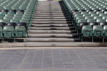 Obraz premium Outdoor lage stair in a stadium. Outdoor stairs between rows of seats. Summer event and outdoor amphitheater.