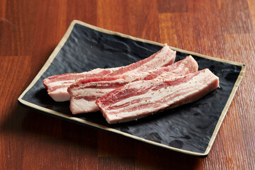 raw pork belly on a plate