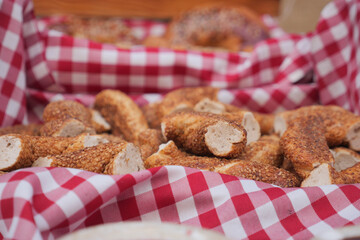 Freshly baked breadsticks arranged on red-checkered cloth