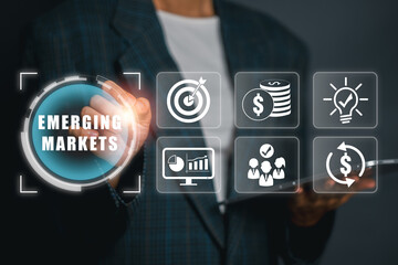 Businessman interacts with digital icons representing emerging markets, showcasing growth, finance, and innovation.