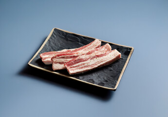 raw pork belly on a plate