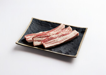 raw pork belly on a plate