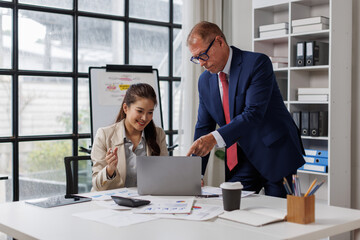 business team standing and planning on board showing charts at corporate office
