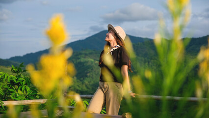 Portrait of a woman standing on wooden terrace and looking at a mountain and nature views
