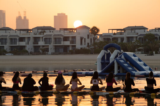 Waterfront and coastal scenes featuring water activities, paddleboards, boats, and urban skylines during different times of day, with reflections on the water and modern city architecture in the back.
