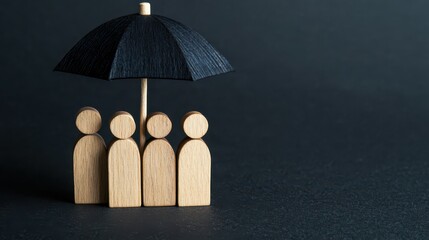A group of wooden figures stands under a small black umbrella, symbolizing protection and unity against adversity.