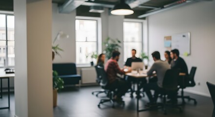 Collaborative business meeting in progress with a group of colleagues in a modern, light-filled office space with a blurred effect