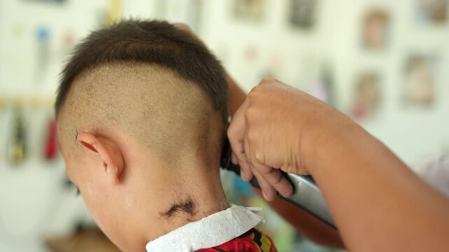 Childs Haircut Experience at Barbershop Close Up of Unique Hairstyle with Clippers, Showcasing Barbers Skill in Grooming and Creating Clean, Modern Look for Boys.