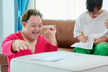 A man with down syndrome are engaging in an activity, displaying happiness and focus. One...