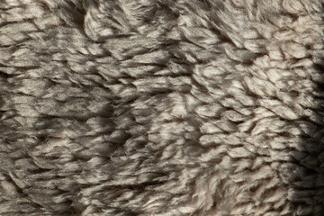 A detailed macro texture of soft beige fleece or sherpa wool fabric, a cozy winter background concept.