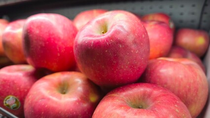 Fresh red apples stacked on a market display. Close-up shot highlighting the vibrant color, natural texture, and freshness, perfect for concepts of healthy eating, organic produce, and nutrition.