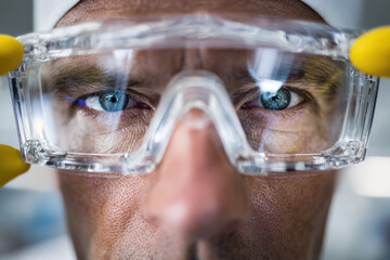Scientist wearing protective glasses analyzing laboratory slides